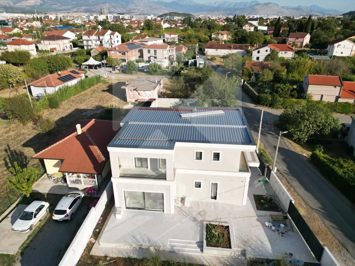 Pogled iz vazduha na novu kuću sa uređenim dvorištem i okruženjem.