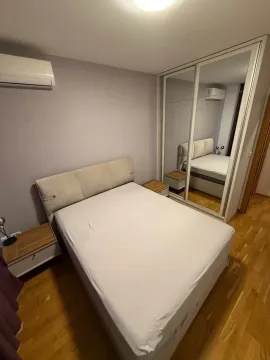 Namještena spavaća soba sa bračnim krevetom, noćnim stočićem i ugradnim ormarom sa ogledalom. - image 4