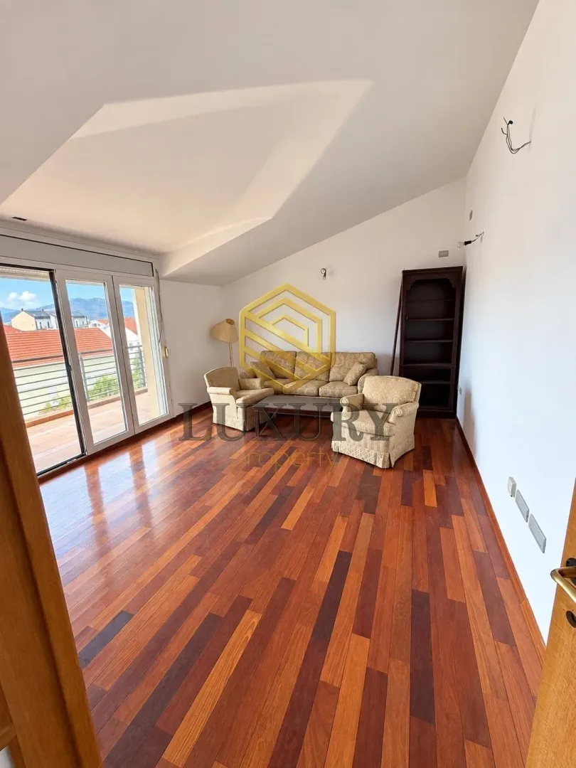 Spacious living room with wooden flooring and a sofa set.