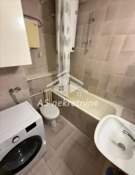 Bathroom equipped with a bathtub, sink, toilet, and washing machine. - image 15