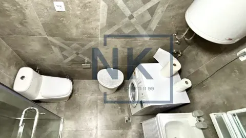 Pogled odozgo na moderno opremljeno kupatilo sa sijem pločica i veš mašinom. - image 10