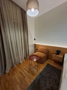 Modern bedroom with a double bed, armchair, and hardwood flooring. - image 7