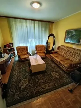 Dnevna soba sa garniturom za sedenje i velikim prozorom sa zavesama. - image 18