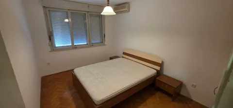 Spavaća soba sa bračnim krevetom, parketom i prozorom sa roletnama. - image 7