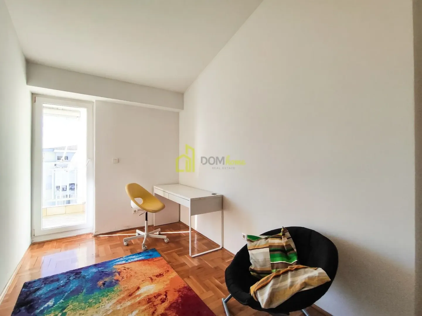 Smaller room with a desk and an armchair, with access to the terrace.