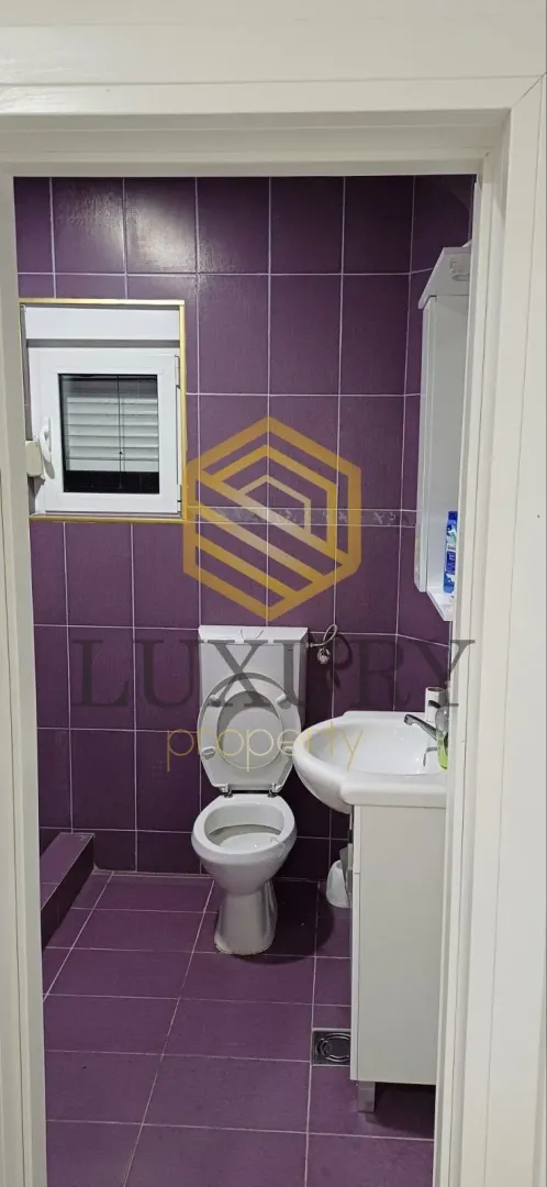 Smaller bathroom with purple tiles and sanitary ware.