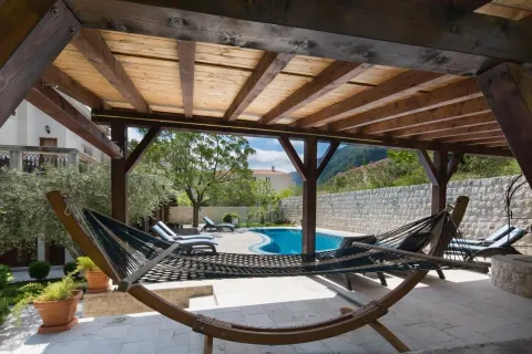 Covered terrace with a hammock and a view of the swimming pool. - image 9