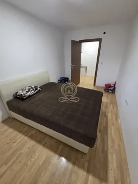 Spavaća soba sa bračnim krevetom i drvenim podom. - image 4
