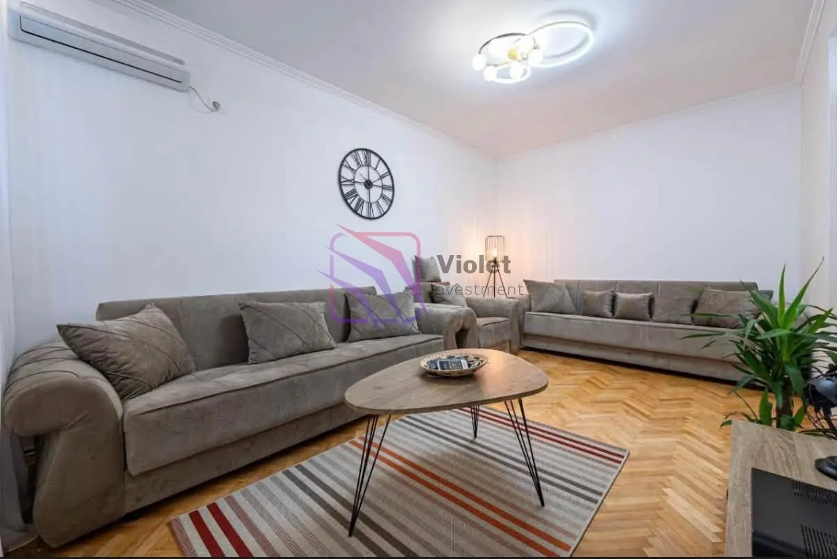 Living room with sofas, a coffee table, and parquet flooring.