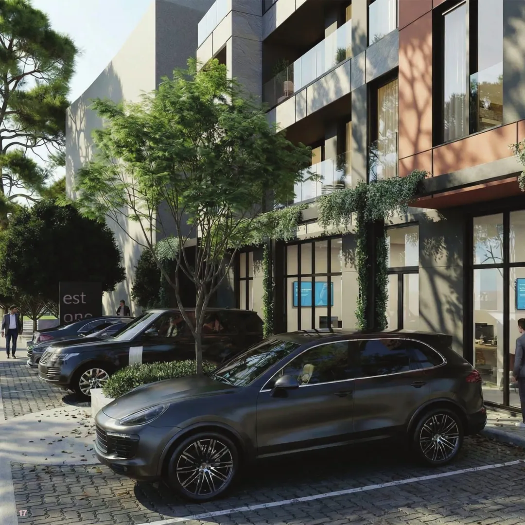 Exterior of a modern residential building with a parking lot and cars parked in front.