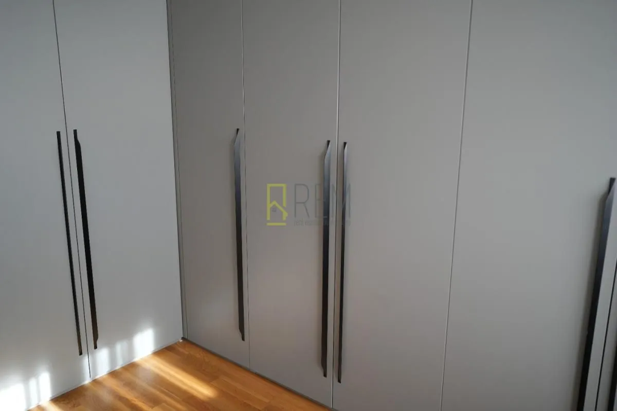 Built-in wardrobe with dark handles in the bedroom.