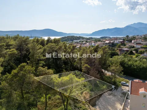 Vazdušni pogled na građevinsku parcelu sa označenim granicama i pogledom na more u pozadini. - image 2