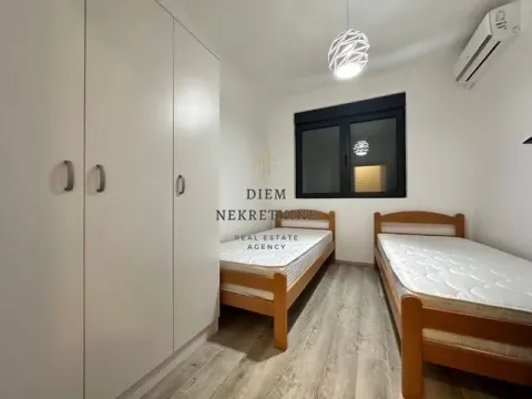 Smaller bedroom with two wooden beds and a large built-in wardrobe. - image 6