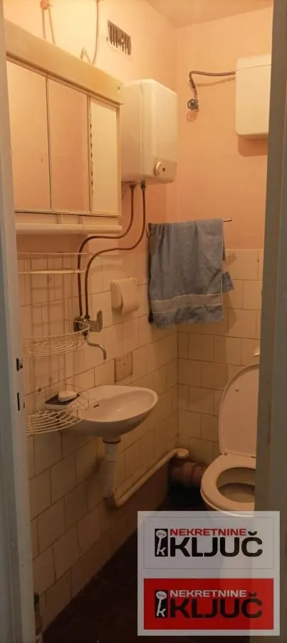 Manje kupatilo sa umivaonikom, WC šoljom i bojlerom.