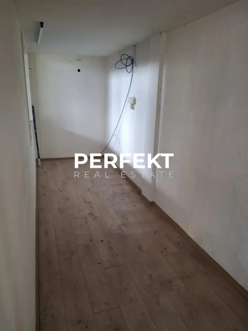 Empty room with laminate flooring and white walls.