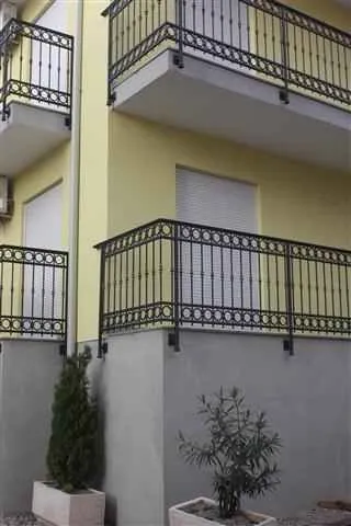 View of the exterior of the building with balconies and decorative railings.