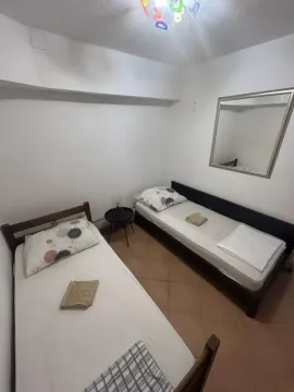 Bedroom with two single beds and a wall mirror. - image 5