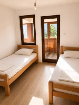 Bedroom with two wooden beds and access to the terrace. - image 2