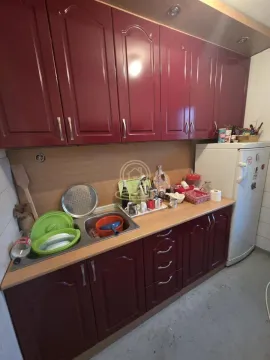 Manja kuhinja sa crvenim kuhinjskim elementima i frižiderom. - image 3