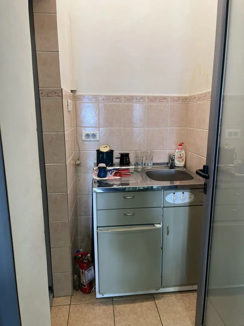 A small kitchenette with a mini fridge and a sink.