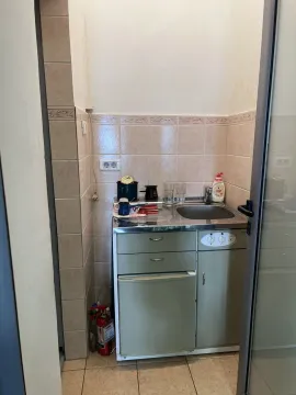 A small kitchenette with a mini fridge and a sink. - image 4