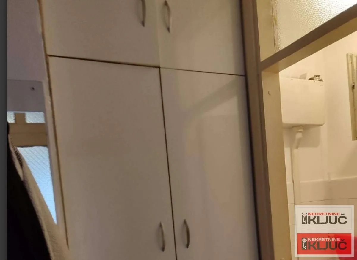 Prikaz dela enterijera sa ugradnim ormanom i prolazom u drugu prostoriju.