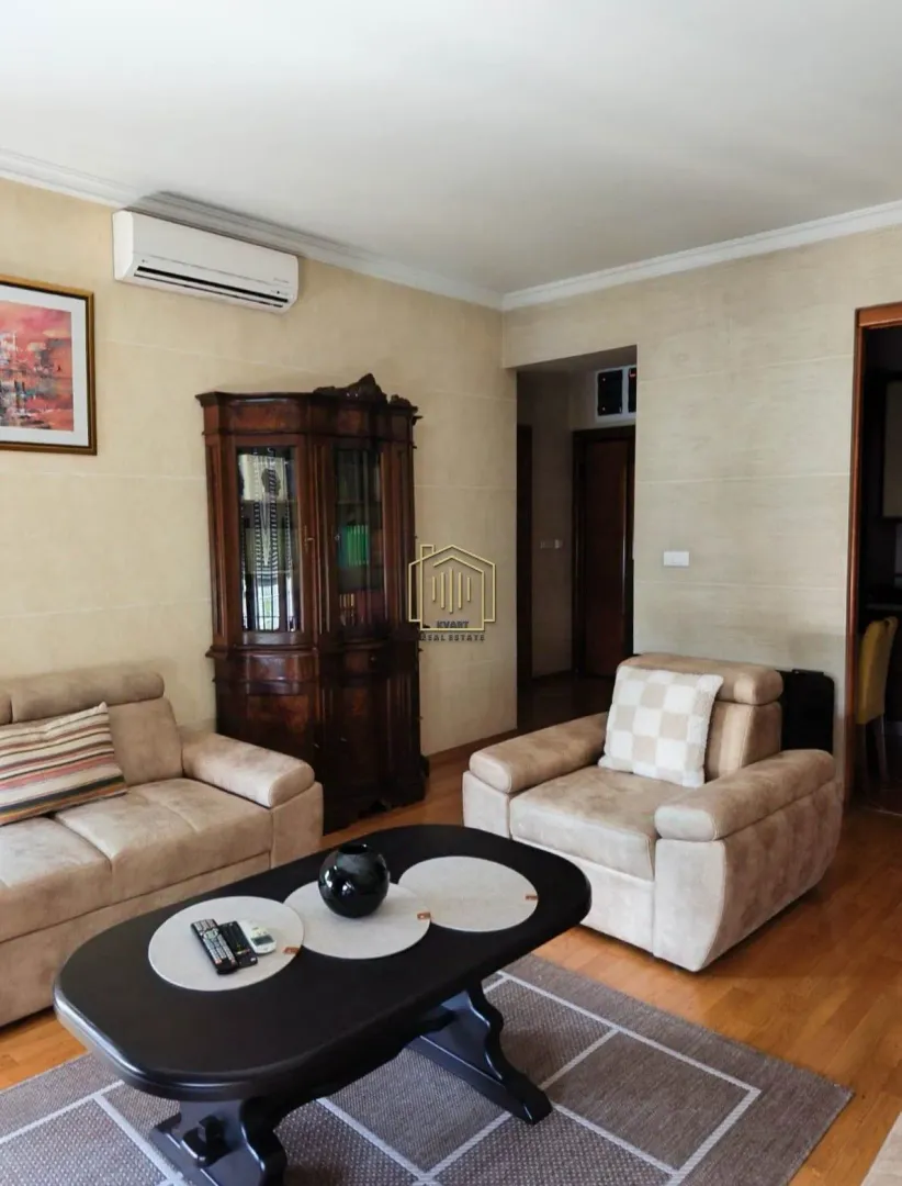 Living room with a seating set, coffee table, and a vintage cabinet.