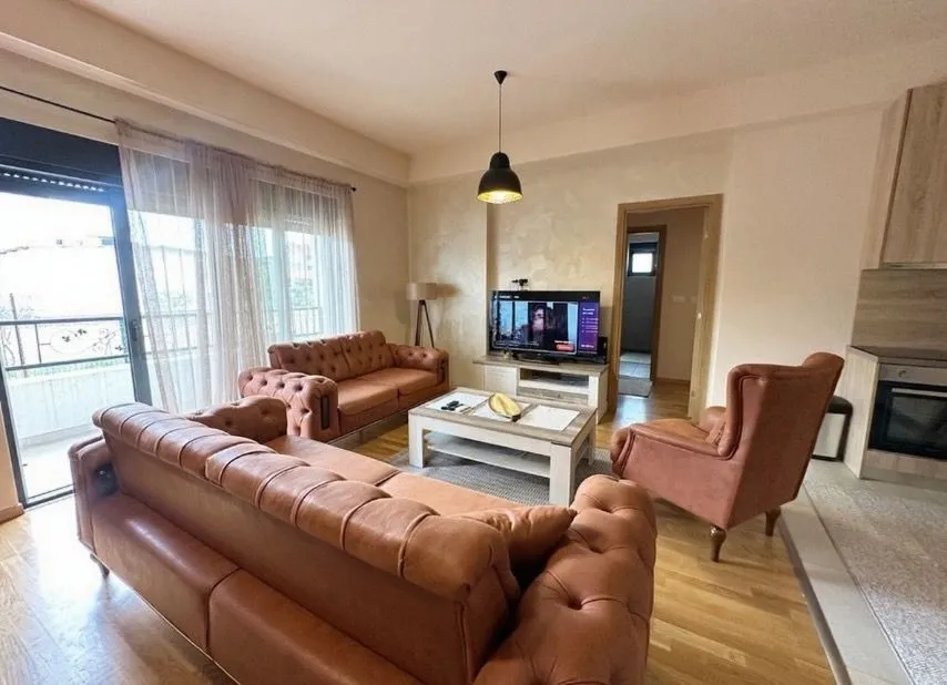Living room with a sofa set, armchair, and TV.