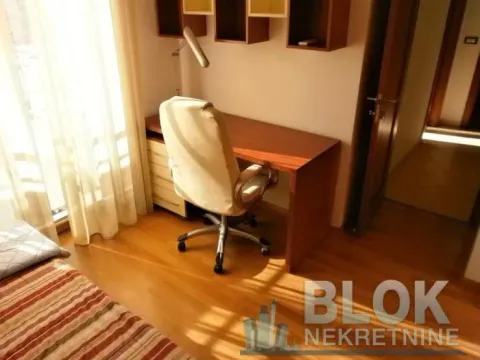 A desk with an armchair and a bed in the bedroom. - image 2