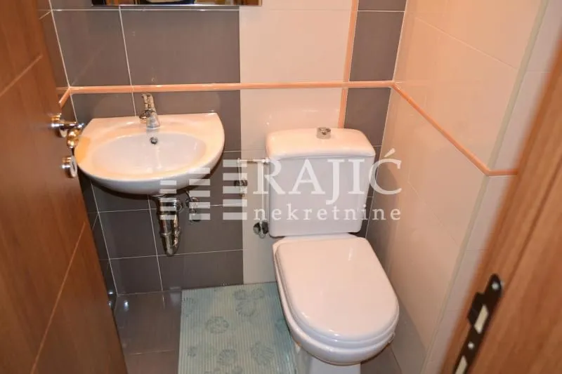 Manje kupatilo sa umivaonikom i wc šoljom.