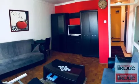 Living room with a sofa set, black furniture and a red wall. - image 5