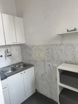 Small kitchen with a sink, white units, and shelves. - image 3