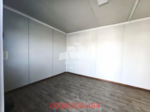 Prazna prostorija sa panelnim zidovima i tamnim laminatom na podu. - image 6