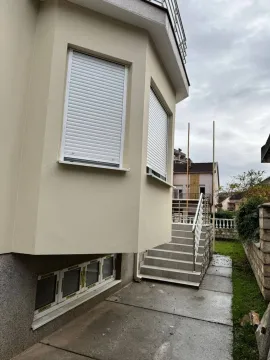 Part of the house facade with closed shutters and outdoor stairs. - image 3