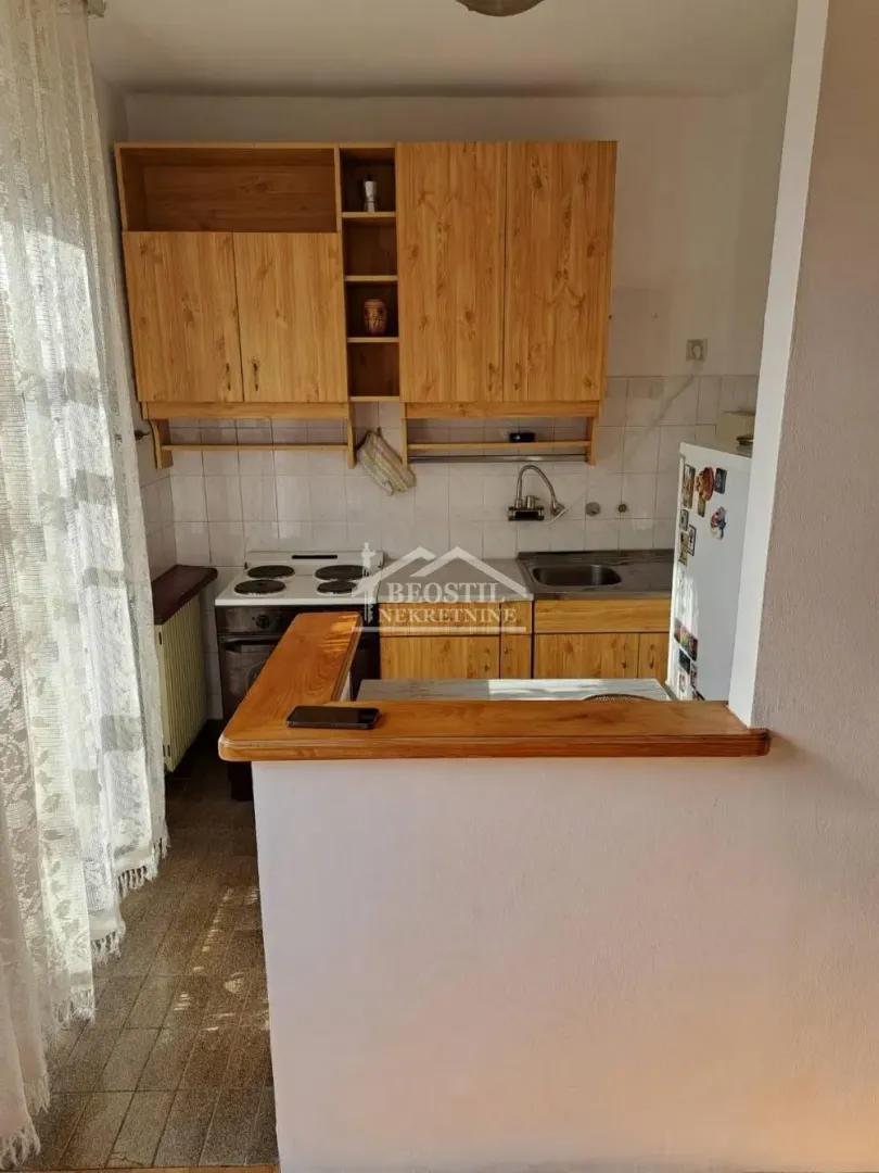 Smaller kitchen with wooden cabinets and a breakfast bar.