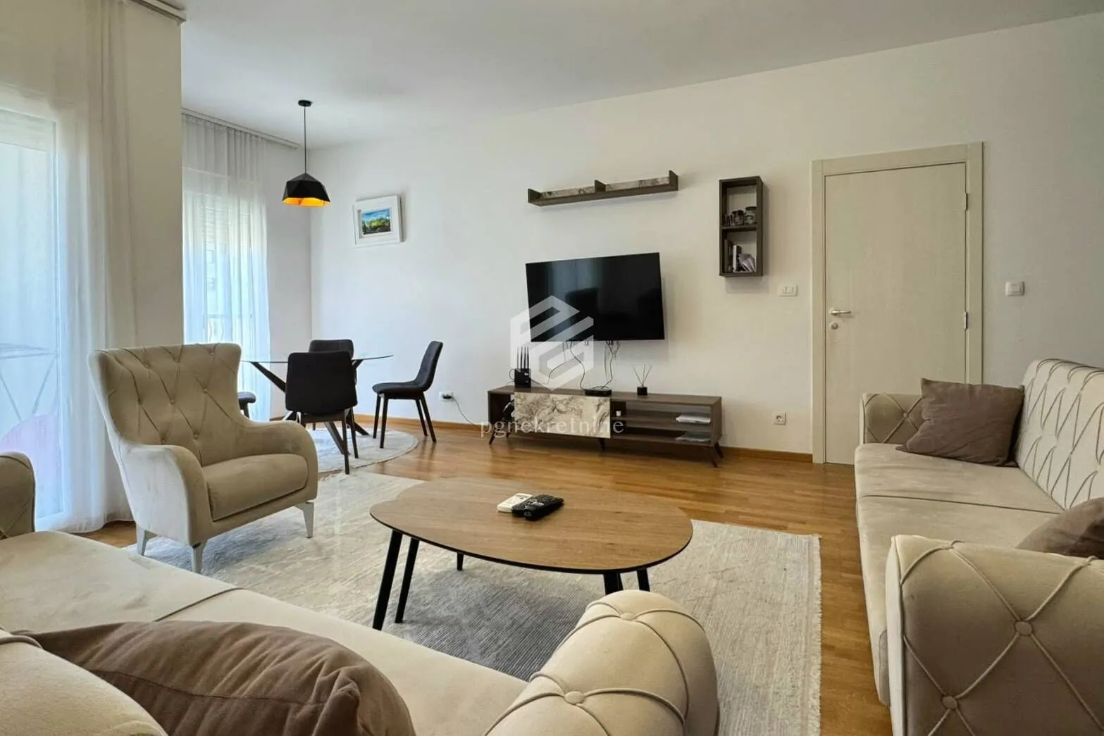 Spacious living room with sofa set, TV, and dining area.