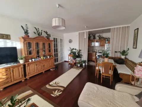Living room with wooden furniture, a TV, and a dining area in the background. - image 9