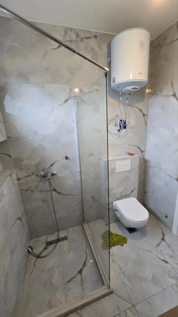 Kupatilo sa tuš kabinom i wc šoljom.