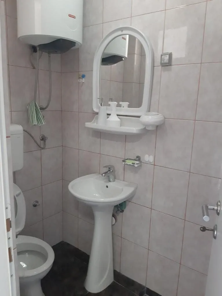 Smaller bathroom with a washbasin, mirror, and toilet.