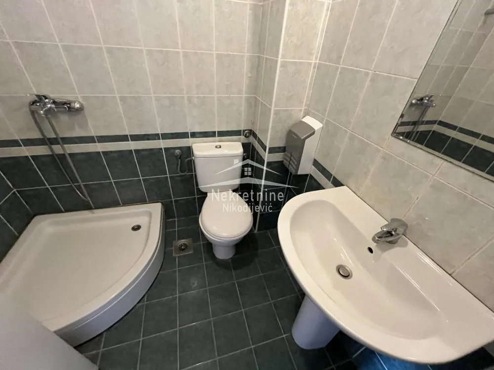 View of the bathroom with a shower cabin, washbasin, and toilet.