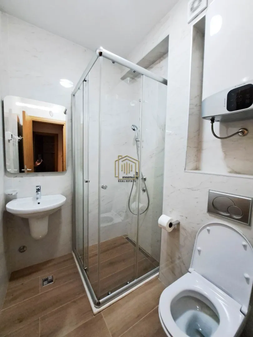 Savremeno opremljeno kupatilo sa tuš kabinom, umivaonikom i WC šoljom.