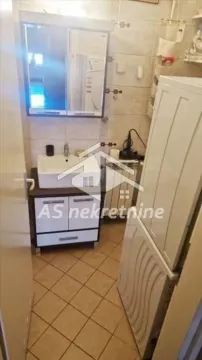 Smaller bathroom with a sink, mirror, and tiles. - image 17
