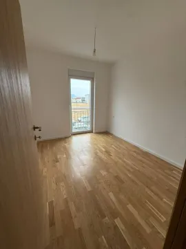 Prazna soba sa drvenim parketom i izlazom na terasu. - image 6
