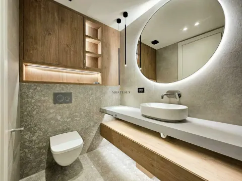 Modernly equipped bathroom with a basin, a mirror, and built-in cabinetry. - image 3