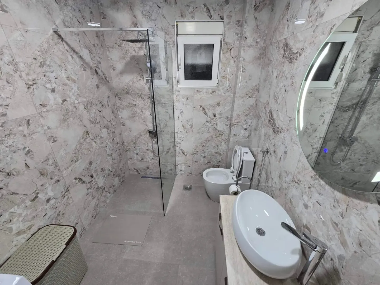 Savremeno opremljeno kupatilo sa tuš kabinom, umivaonikom i wc šoljom.