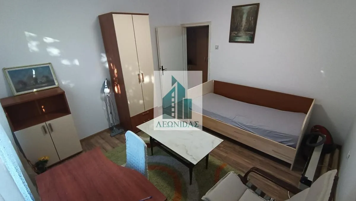 Furnished bedroom with a bed, wardrobe, and desk.
