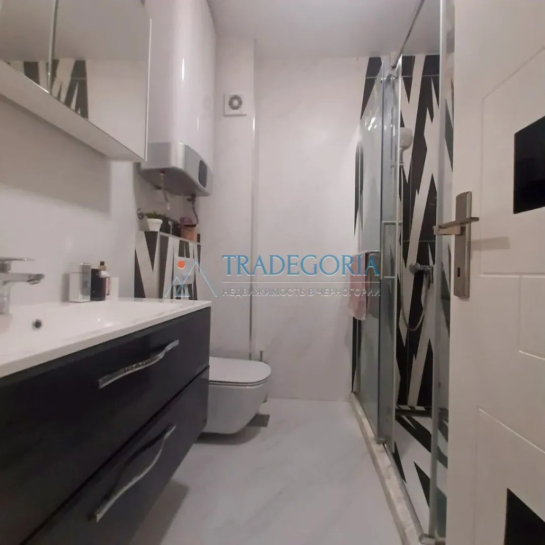 Moderne kupatilo sa umivaonikom, WC šoljom i tuš kabinom.