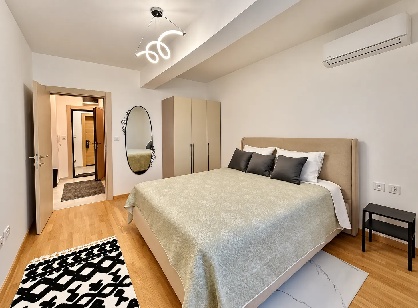 Modern bedroom with a double bed, wardrobe, and air conditioning.
