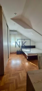 Attic bedroom with a double bed, wardrobe, and parquet flooring. - image 9