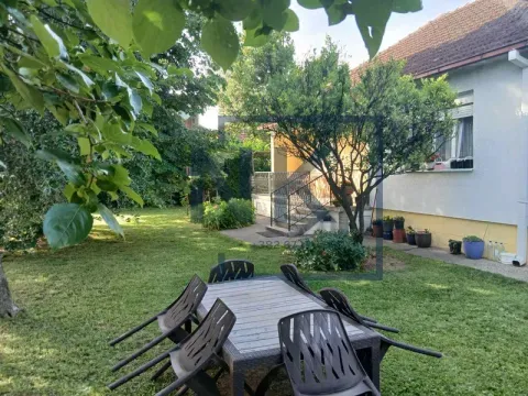 Uređeno dvorište sa garniturom za sedenje i zelenilom ispred kuće. - image 2